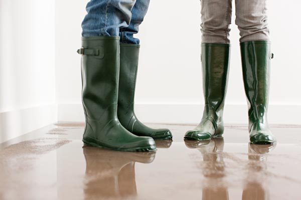 Two people standing in a Utah home flood, you see only their boots, standing in water