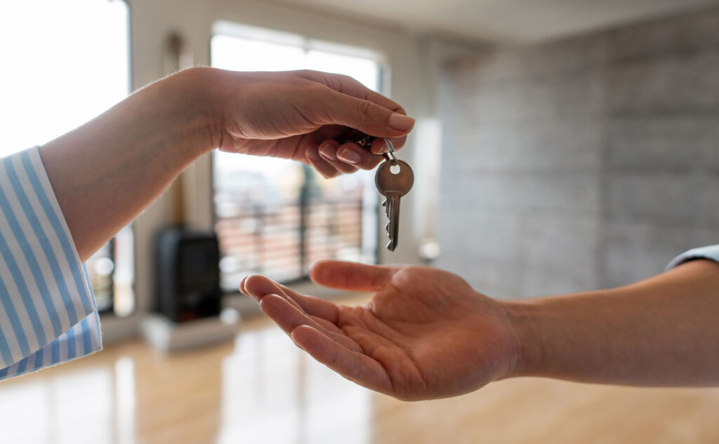 Utah home rental showing a person handing over the key to a rental property, you only see their hands